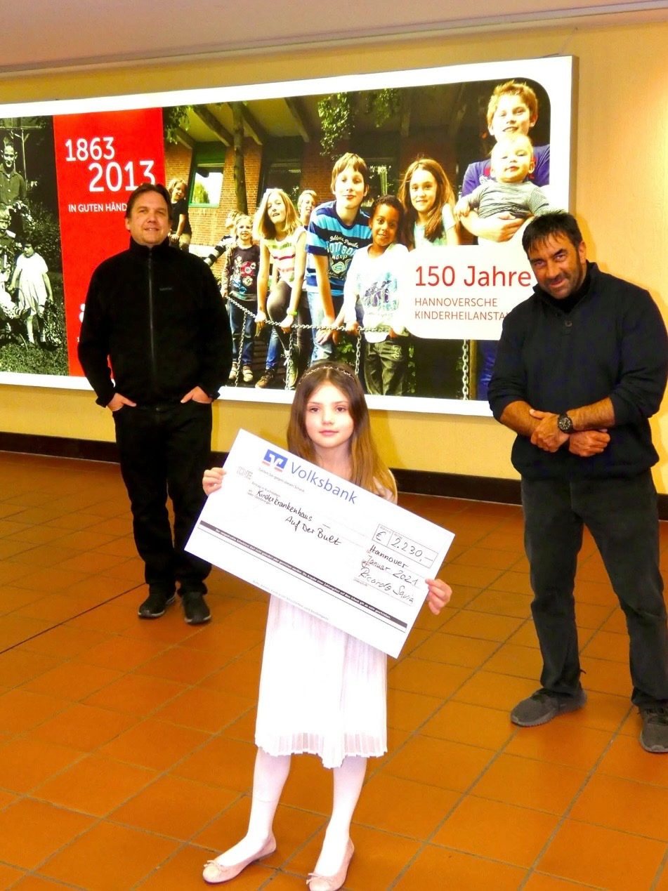 Ein Kind mit einem Spendenscheck für Auf der Bult